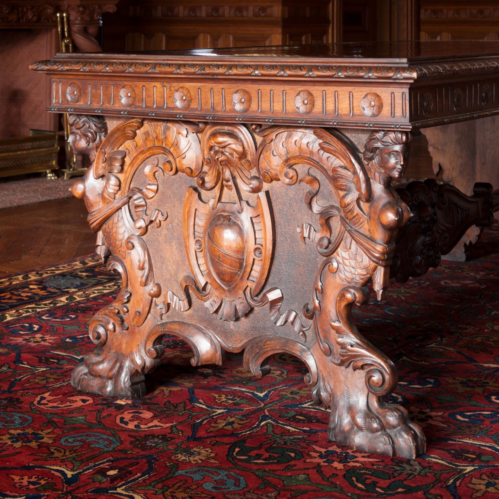 Ornately carved wooden table on carpet.
